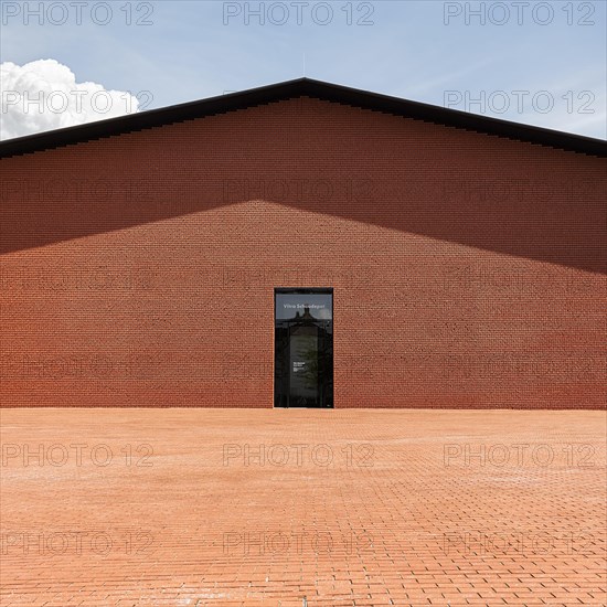 Windowless red brick building in the shape of a warehouse