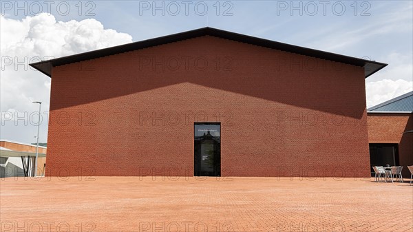 Windowless red brick building in the shape of a warehouse