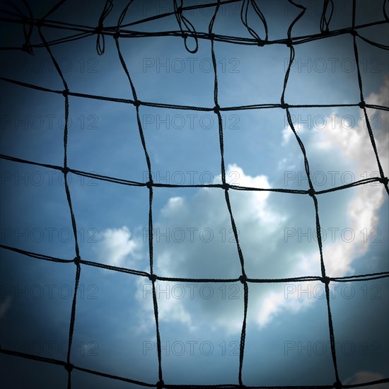 Football goal net against cloudy sky