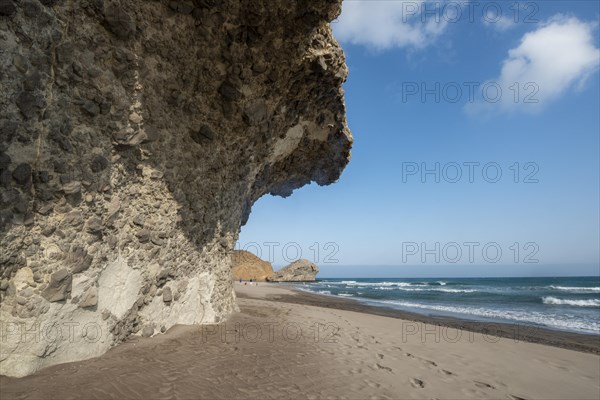 Petrified lava tongues and rocky coast at the beach Playa del Monsul