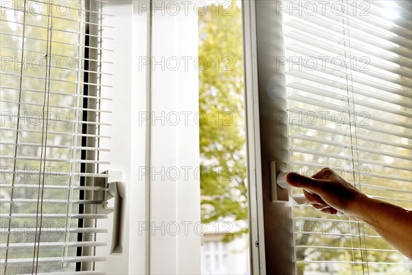 Person opens window in office and wants to air