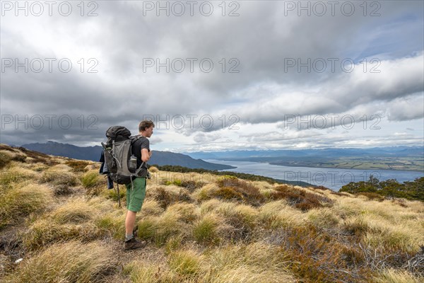 Hiker looks out over Lake Te Anau and Southfiord