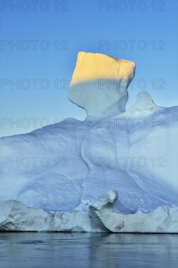 Evening atmosphere with sunlit iceberg
