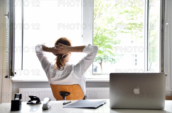 Woman sitting in the office with the window open