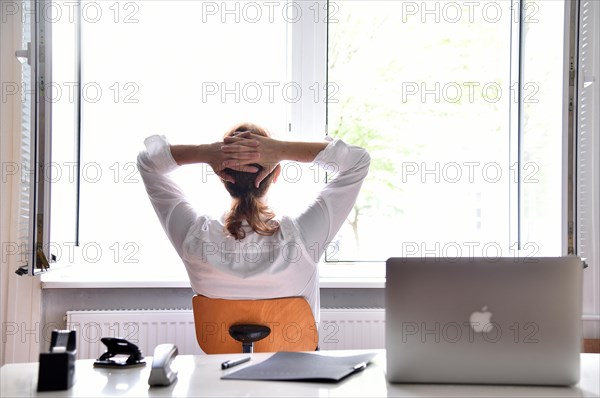 Woman sitting in the office with the window open