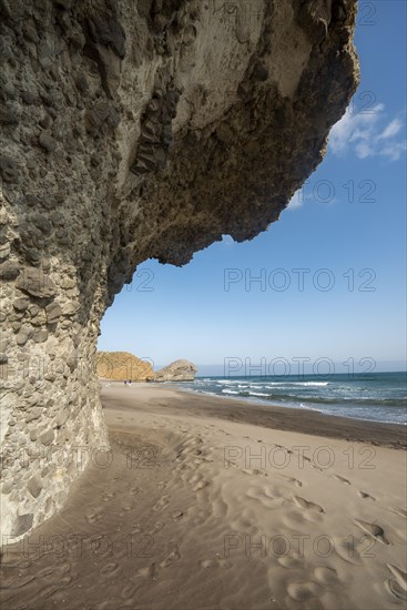 Petrified lava tongues and rocky coast at the beach Playa del Monsul