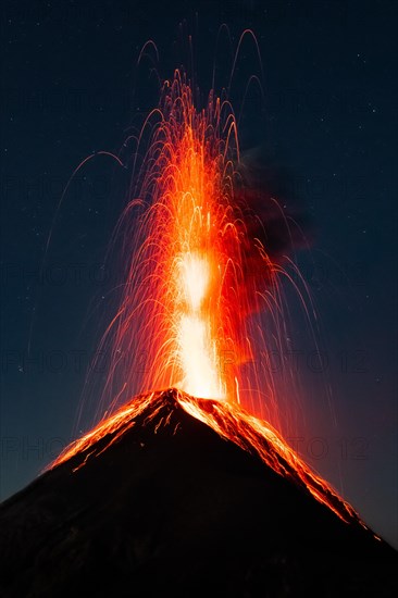 Glowing lava and smoke spitting volcano