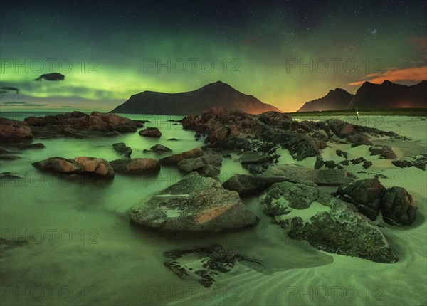 Northern lights over rocky beach