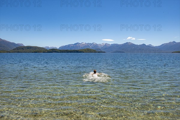 Young man bathes in the lake