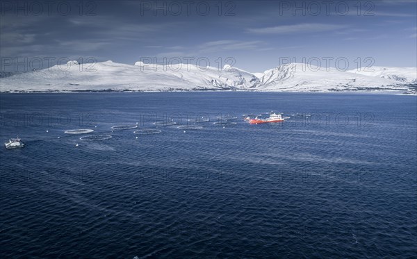 Salmon farm with supply boat in a fjord