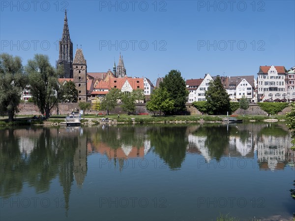 Ulm Cathedral and buildings on the banks of the Danube with water reflection
