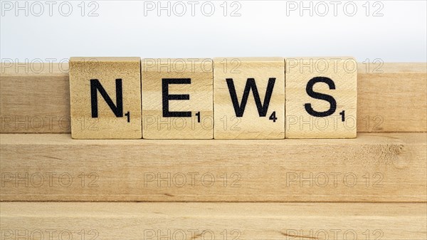 Letter blocks on a wooden bar form the word News