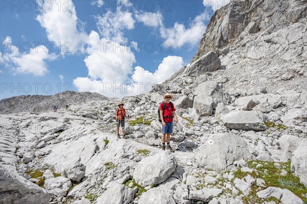 Two hikers in a landscape of washed out karst rocks