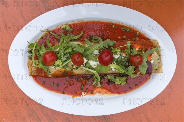 Stuffed pancakes with rocket and tomato sauce