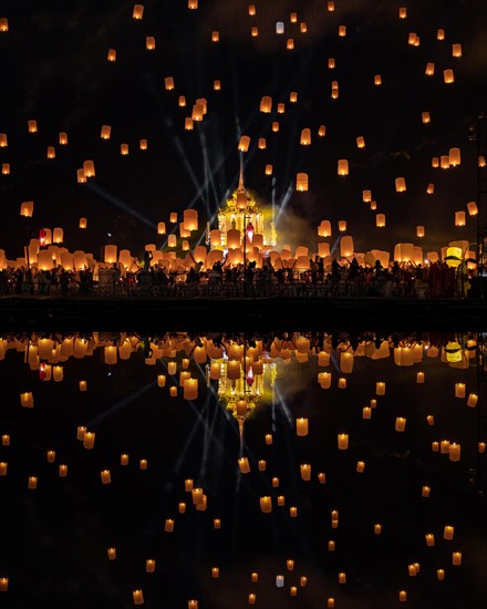 Yi Peng Festival with rising lanterns and a reflection in the lake