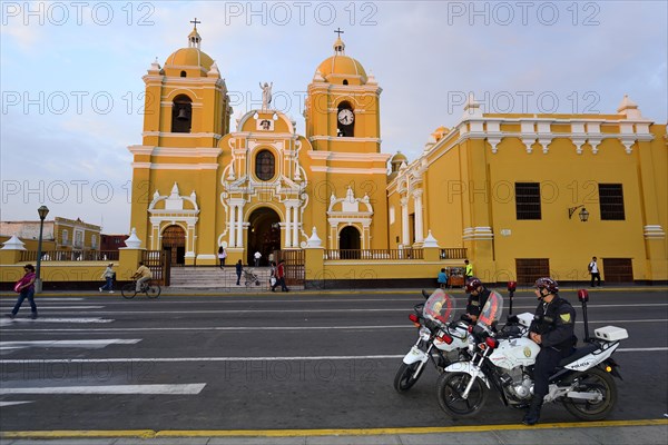 Two policemen on motorcycles in front of the cathedral in the evening light