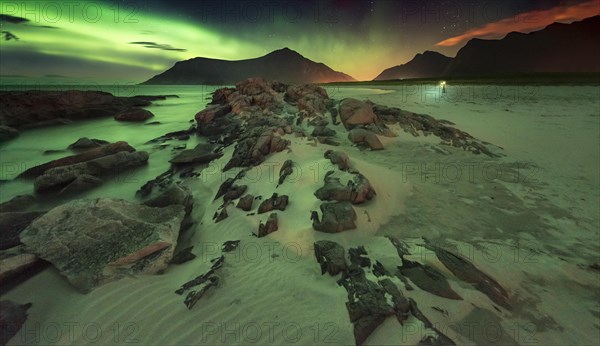 Northern lights over rocky beach