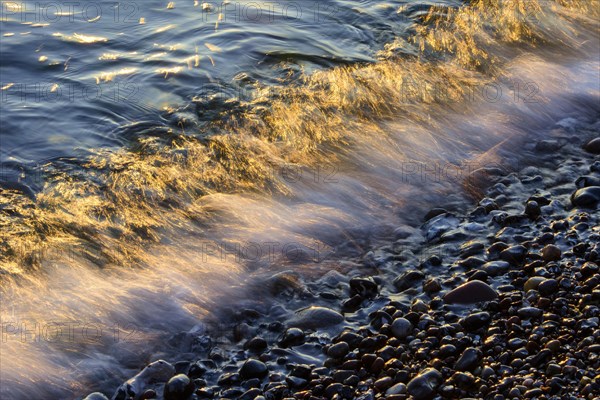 Waves and spray on the beach at sunrise