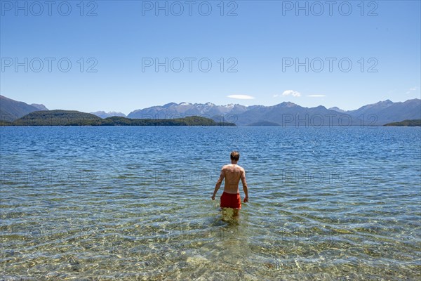 Young man bathes in the lake