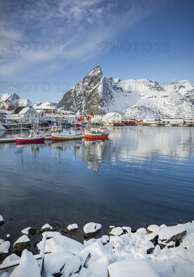 Fishing village with fishermen's cabins and jetty in winter by the fjord