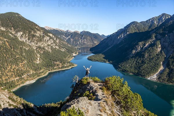 Hiker stretches out his arms in the air