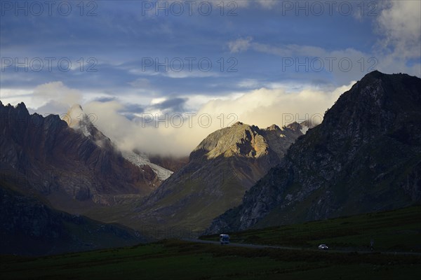 Evening sun on the mountains above the winding mountain road