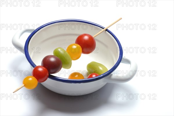 Various cherry tomatoes on wooden skewers on a bowl