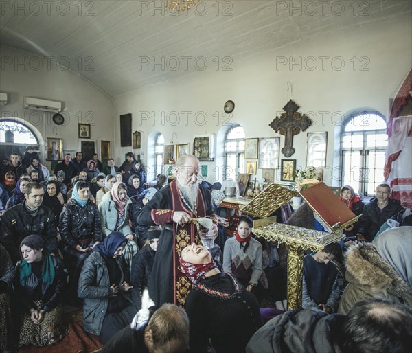 Father Sergei during an exorcism in his church in Ochamchira