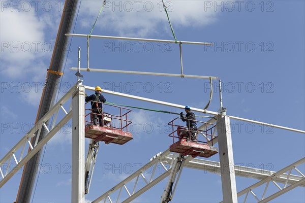 Two construction workers on working platforms