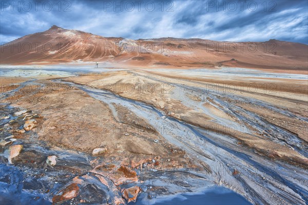 Woman with photo tripod standing in the Hverir thermal field