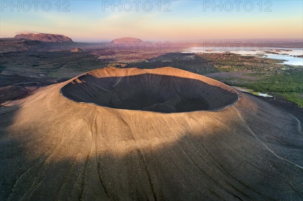 Aerial view of the tuffring crater Hverfjall in the evening light in the Krafla volcano system in the Myvatn region rising out of a green plain