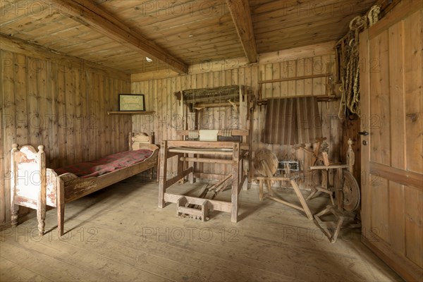 Interior view of a historic bedroom with bed and checked ceiling