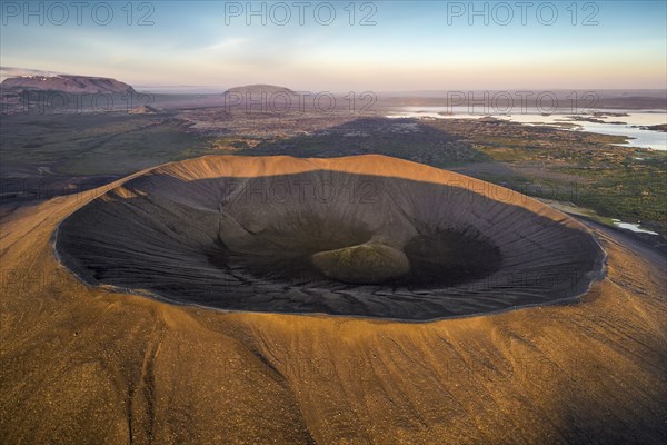 Aerial view of the tuffring crater Hverfjall in the evening light in the Krafla volcano system in the Myvatn region rising out of a green plain