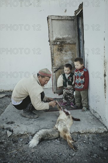 Eagle hunter Bashakhan Spai skins and carves a fox