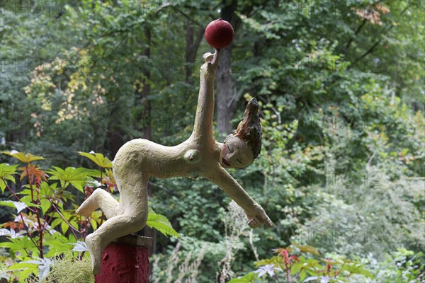 Naked gymnast balancing ball