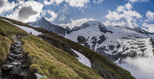 Hiking trail in front of snow-covered mountain peaks