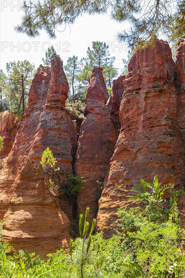 Red pyramid-shaped rocks in the natural park of ochre rocks in Roussillon
