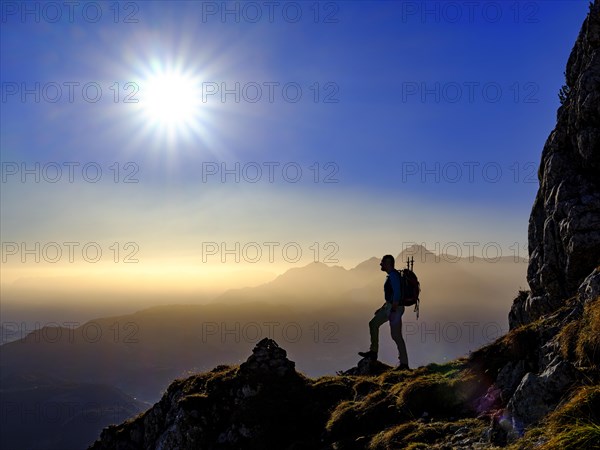 Silhouette of a mountaineer on an exposed path in the morning sun