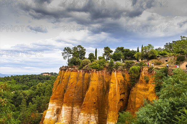 Steep cliffs in the natural park of ochre cliffs with dramatic clouds above