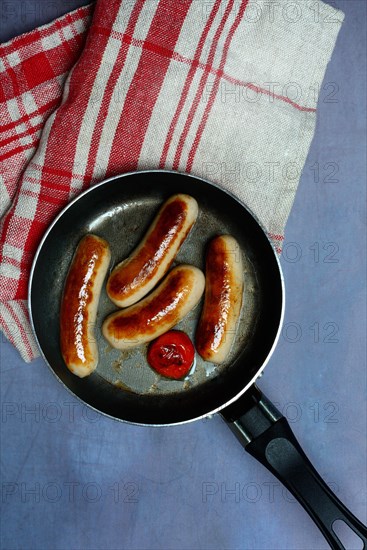 Chipolata sausages in pan