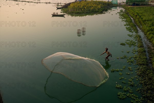 Fishermen on Taung Tha Man Lake throw out a fishing net for sunrise