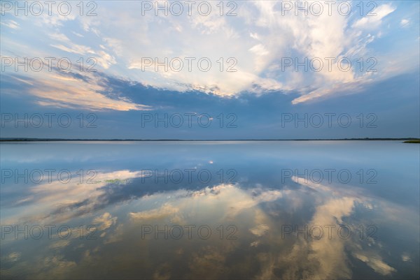 Clouds reflected at sunrise on the smooth lake