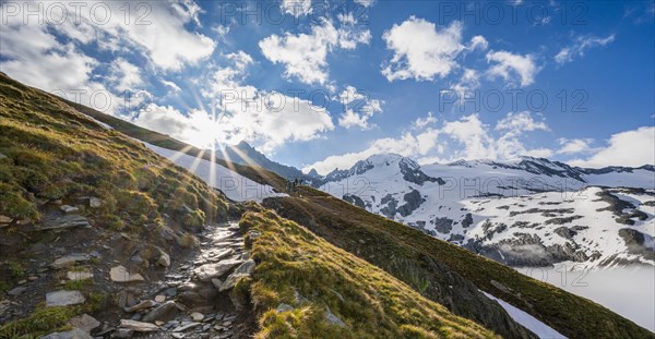 Hiking trail in front of snow-covered mountain peaks