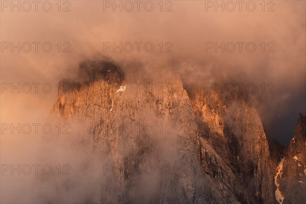 Rock face framed by clouds at sunset