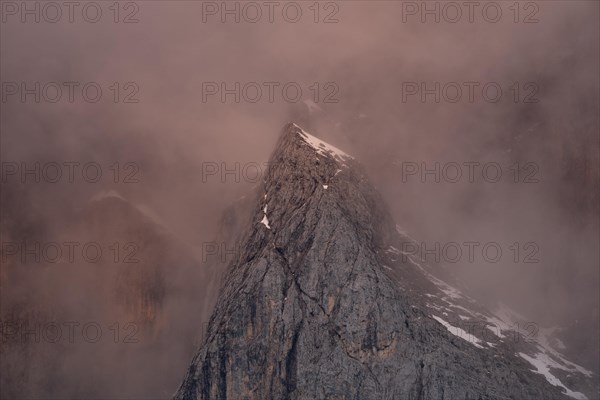 Rock face framed by clouds at sunset