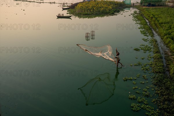 Fishermen on Taung Tha Man Lake throw out a fishing net for sunrise