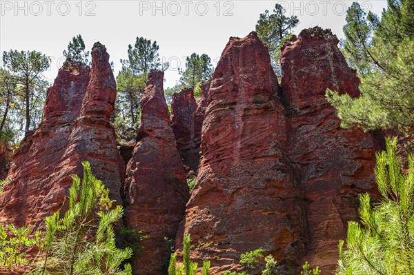 Red pyramid-shaped rocks in the natural park of ochre rocks in Roussillon