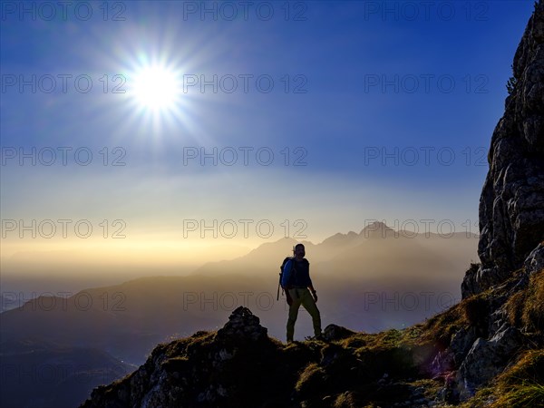 Silhouette of a mountaineer on an exposed path in the morning sun