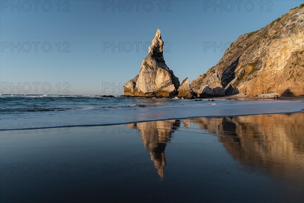Marked rocks at Praia da Ursa beach with reflection