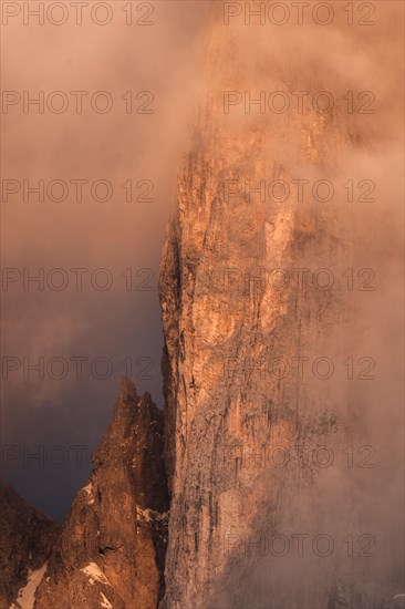 Rock face framed by clouds at sunset